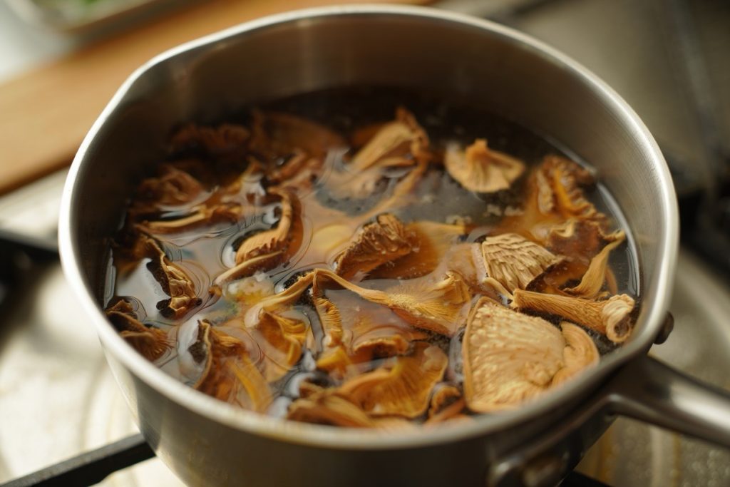 champignons séchés en train d'être réhydratés dans un bouillon