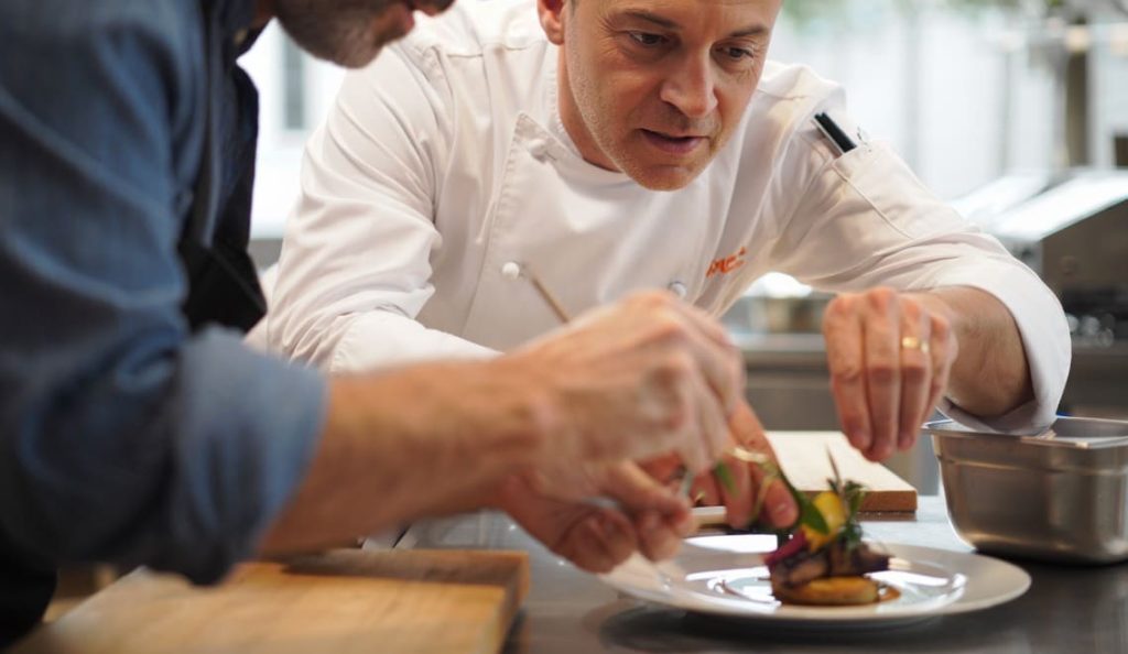 chef cuisinier qui accompagne un cuisinier amateur lors d'un cours