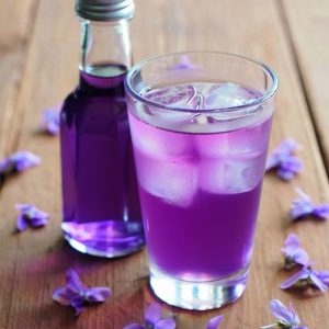bouteille et verre de sirop de violette fait maison