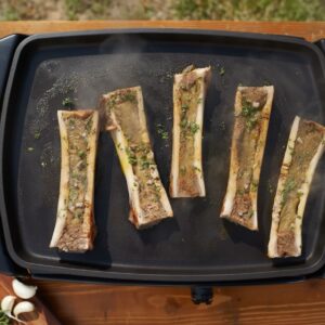 des os à moelle en train de cuire sur une plancha