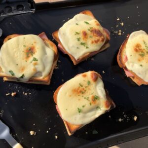 4 croques en train de cuire sur une plancha électrique